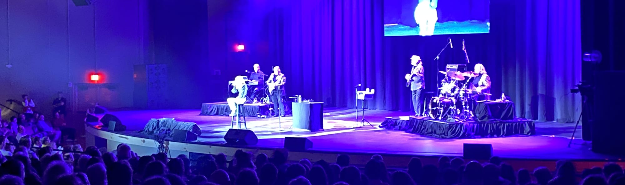 signer on stage in chair washed out by the lights Durham